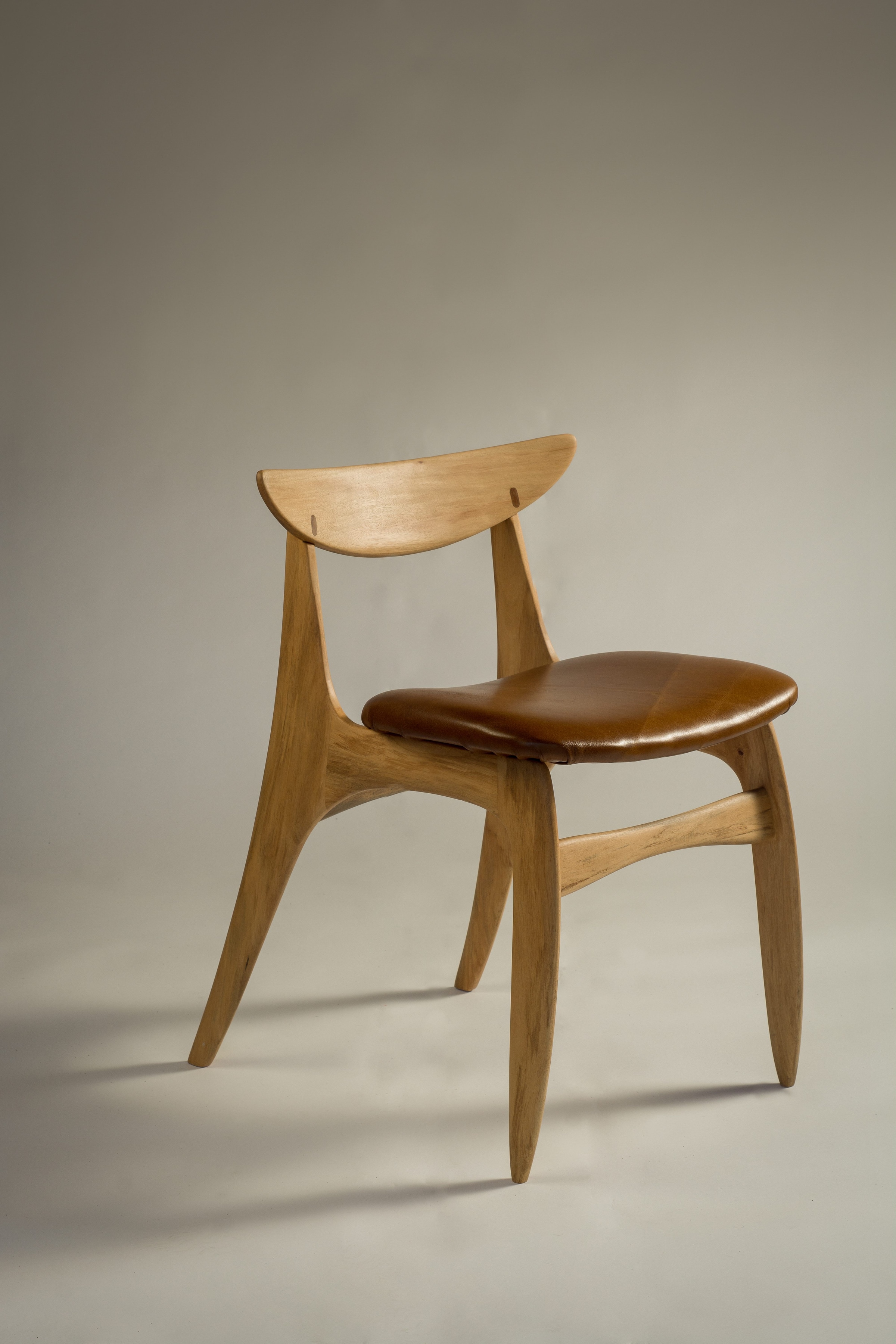 Wooden dining chair shown from a three-quarter angle
